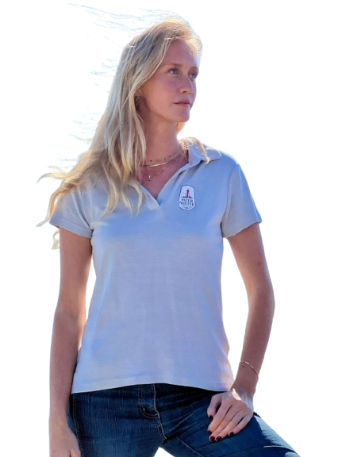 Alt text (SEO-optimized): Woman wearing a white Reparell polo shirt made from recycled OceanWaste, AutoWaste, and Tencel, standing by the ocean representing sustainable, LCA-verified textile production in Portugal.